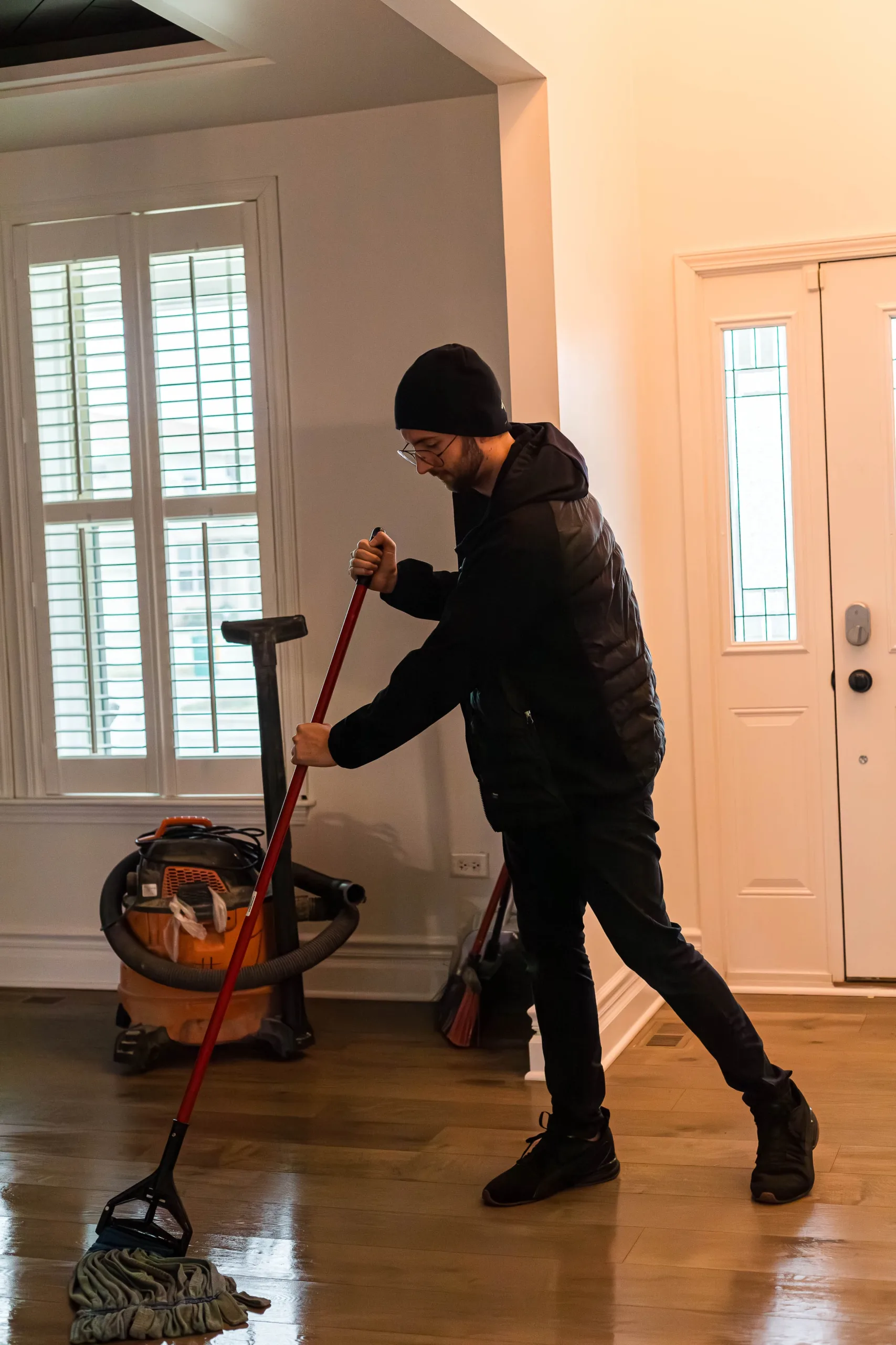 A Keep It Clean employee mopping a residential floor, displaying the company's commitment to thorough home cleaning services.